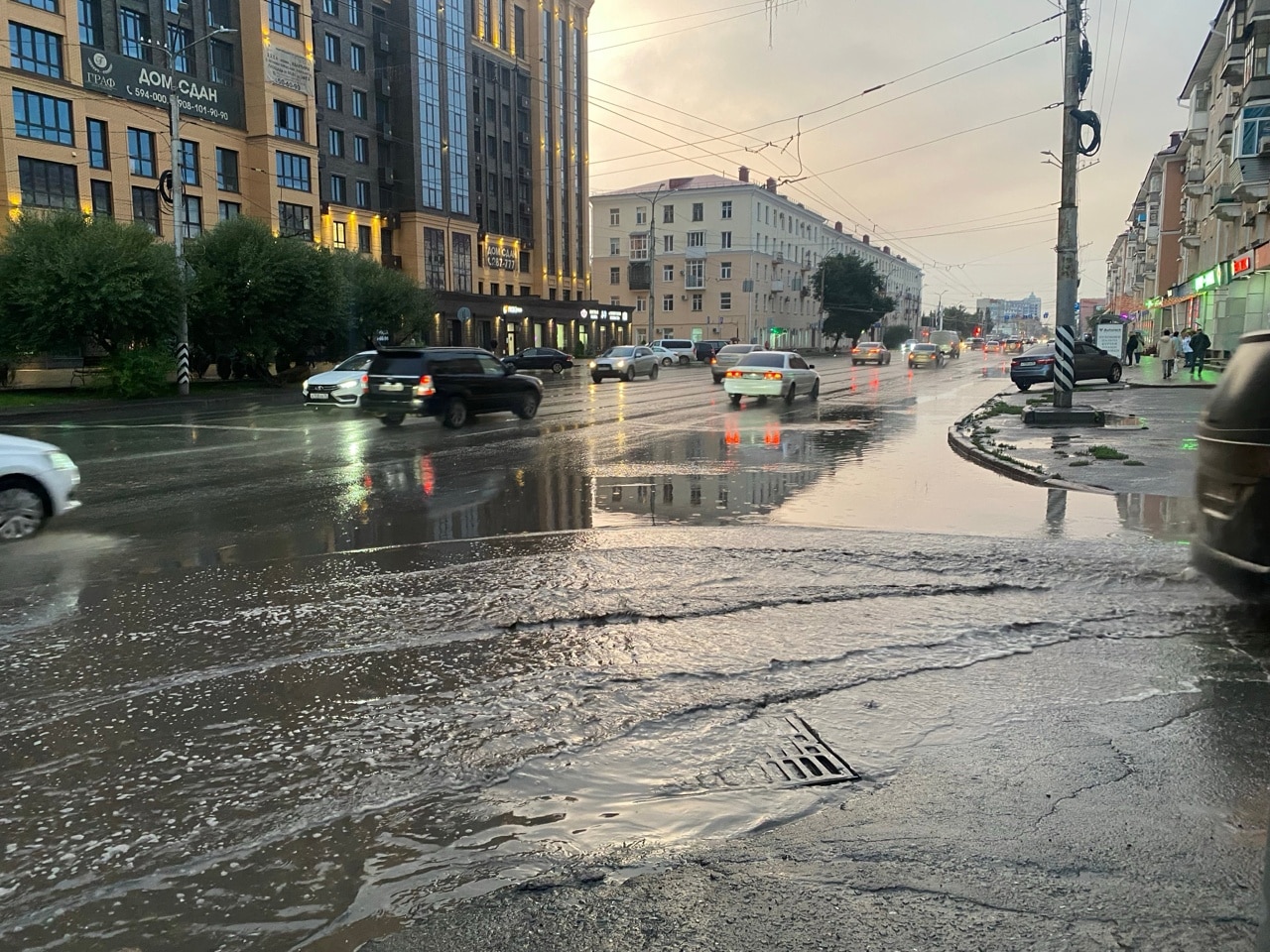 Омичка упала в грязь у дороги, пока обходила затопленный пешеходный переход - на проспекте Маркса образовалось море